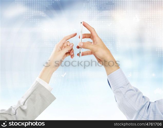 Interaction concept. Two business people using one mobile phone at the same time