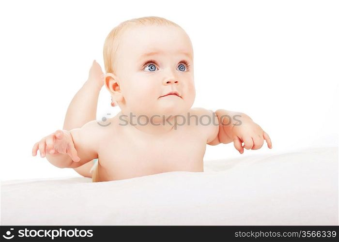 interested child lays on white fabric