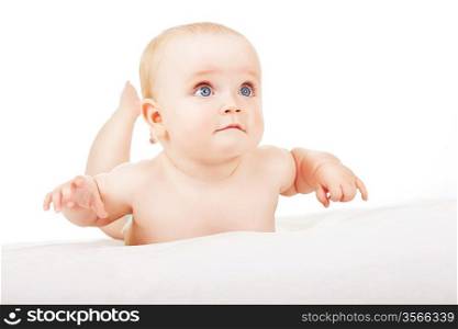 interested child lays on white fabric
