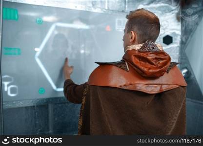 Intergalactic space scientist enter data on the teleport board, spacecraft with foil walls. Fantasy spaceship for interstellar travel, future science and technology. Space scientist enter data on the teleport board