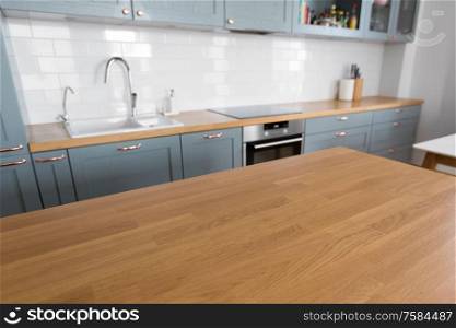 interior and cooking concept - modern kitchen counter and wooden table at home. home kitchen interior with counter and table