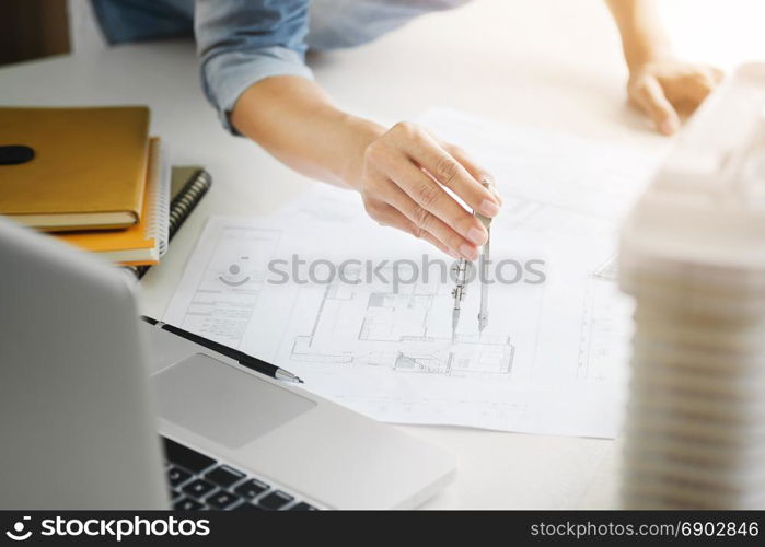 interior Architect working on blueprint with engineering tools