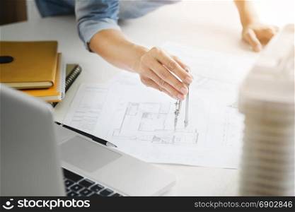 interior Architect working on blueprint with engineering tools