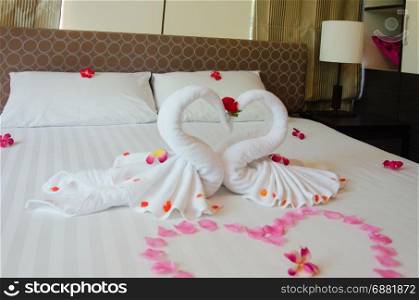 Interior bedroom Swan towel And orchid flowers on the bed. The hotel rooms are romantic for couples.