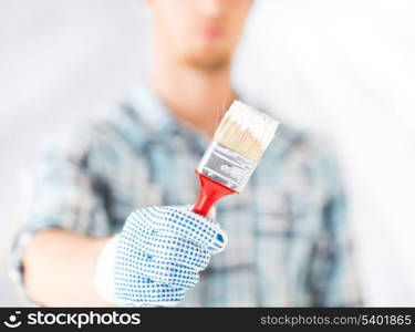 interior design and home renovation concept - man hand with paintbrush