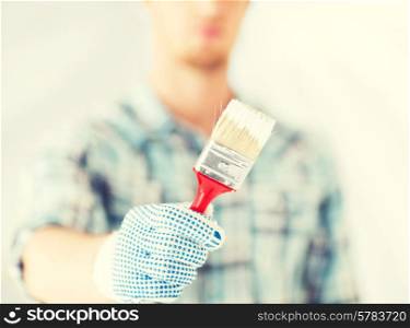interior design and home renovation concept - man hand with paintbrush