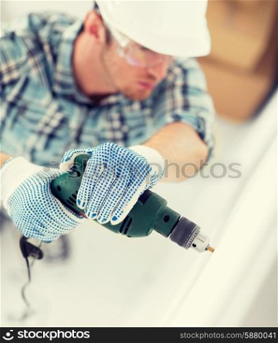 interior design and home renovation concept - man in helmet with electric drill making hole in wall