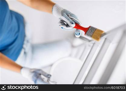 interior design and home renovation concept - woman with paintbrush and paint pot. woman with paintbrush and paint pot