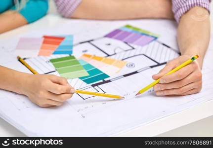 interior design, architecture and people concept - close up of architects team working with blueprint and color palettes. close up of architects team working with blueprint