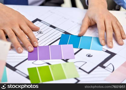 interior design, architecture and people concept - close up of designers team working with blueprint and color palettes. close up of designers team working with blueprint