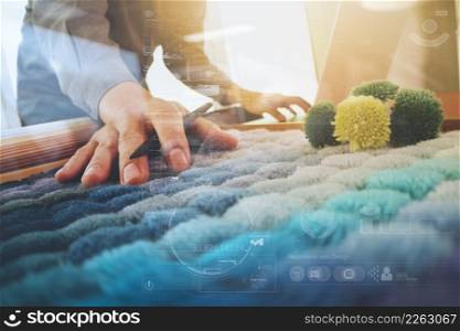 Interior designer hand chosing carpet sample with blank new modern computer laptop and pro digital tablet with material board and digital design diagram layer on wooden desk as concept