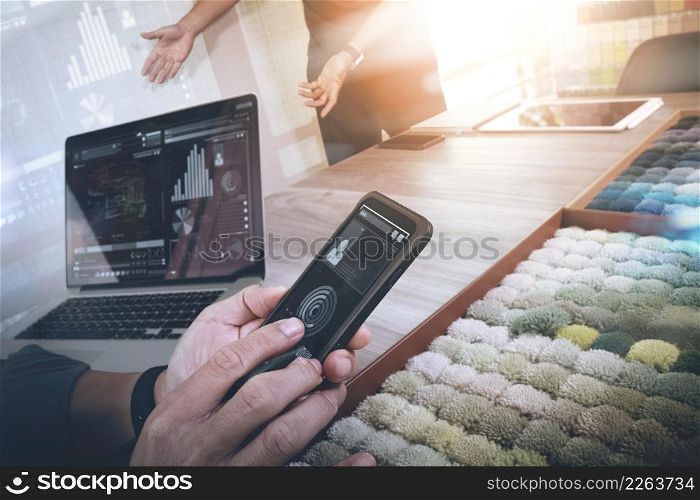 Interior designer hand using smart phone and choosing carpet sample with blank new modern computer laptop and digital tablet with material board on wooden desk as concept