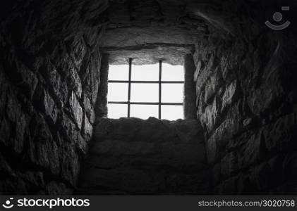 Interior image from an old basement built of stone with the barred window