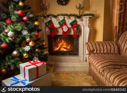 Interior image of living room with burning fireplace, decorated Christmas tree