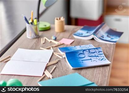 interior, mess and education concept - school supplies scattered on table at home. school supplies scattered on table at home