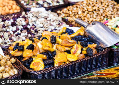 Interior of a busy food market, with detail on peanuts and almonds baskets