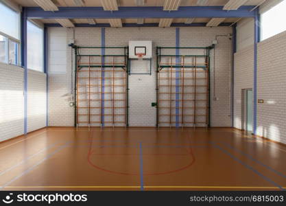 Interior of a gym at school, jumping high at the basket