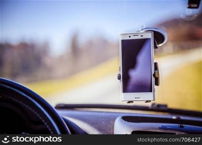 Interior of a modern car on a sunny day. Smartphone on mobile mount, used as navigation device
