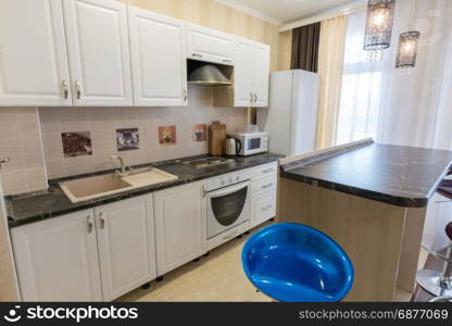 Interior of a one-room apartment, view of a kitchen set