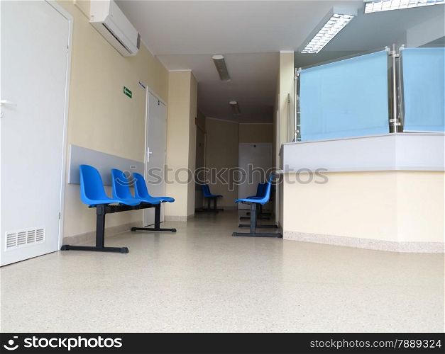 Interior of a waiting room blue stools, empty chairs.