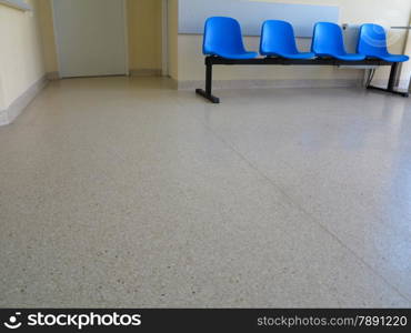 Interior of a waiting room blue stools, empty chairs.