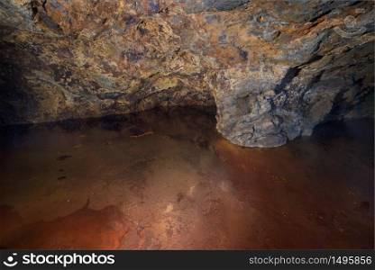 Interior of an old Pyrite mine, a red mineral toned lake has been formed in the foreground, La Union, Murcia, Spain