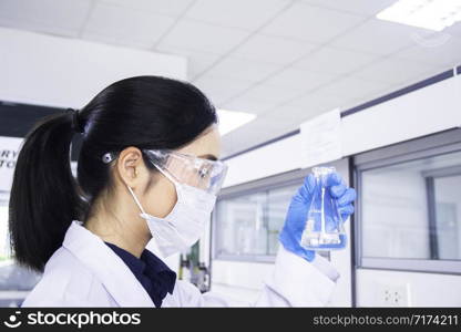 Interior of clean modern medical or chemistry laboratory background. Scientist working at a lab. Laboratory concept with Asian woman chemist.