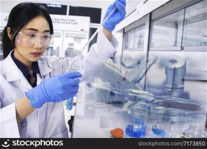 Interior of clean modern white medical or chemistry laboratory background. Laboratory scientist working at a lab with pipette and test tubes. Laboratory concept with Asian woman chemist.