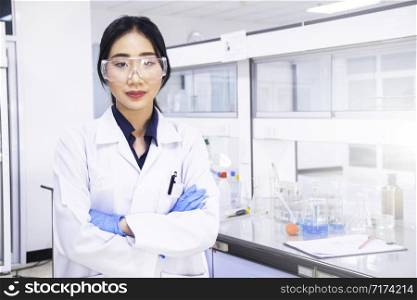 Interior of clean modern white medical or chemistry laboratory background. Laboratory scientist working at a lab with micropipette/pipette and test tubes. Laboratory concept with Asian woman chemist.