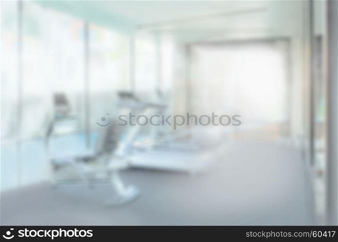 interior of modern fitness center gym with equipment, abstract blur background