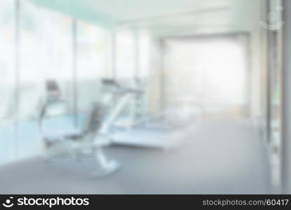 interior of modern fitness center gym with equipment, abstract blur background