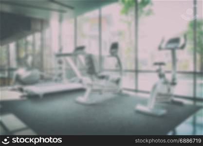 interior of modern fitness center gym with equipment, abstract blur background