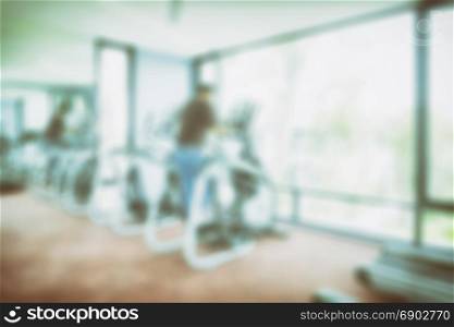 interior of modern fitness center with equipment, abstract blur background
