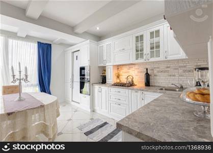 interior of modern white wooden kitchen in luxury home. modern white wooden kitchen interior