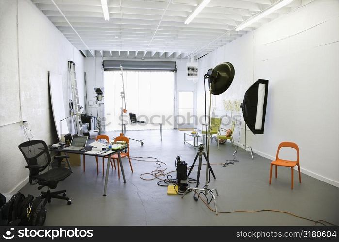 Interior of photography studio with lights and various equipment and props.