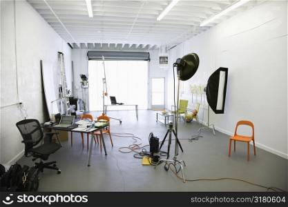 Interior of photography studio with lights and various equipment and props.