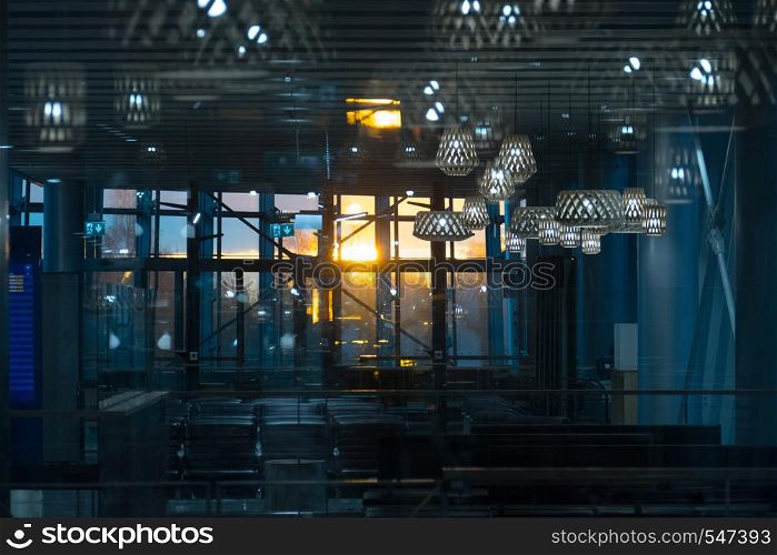interior of the airport hall in the evening, through panoramic glass the rays of the sun pass.. Helsinki, Finland - January 15, 2018: interior of the airport hall in the evening, through panoramic glass the rays of the sun pass