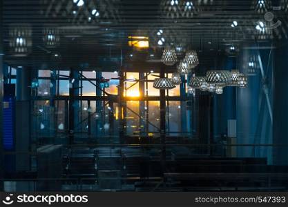 interior of the airport hall in the evening, through panoramic glass the rays of the sun pass.. Helsinki, Finland - January 15, 2018: interior of the airport hall in the evening, through panoramic glass the rays of the sun pass