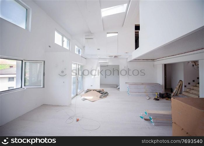 Interior of unfinished stylish modern open space two level apartment with white walls soon ready to move in