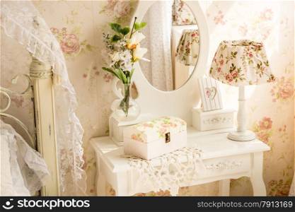Interior photo of table with mirror and flowers in provence style