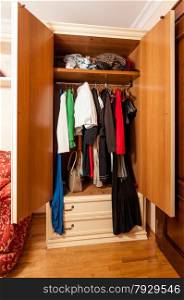 Interior photo of wardrobe with clothes on hangers in it