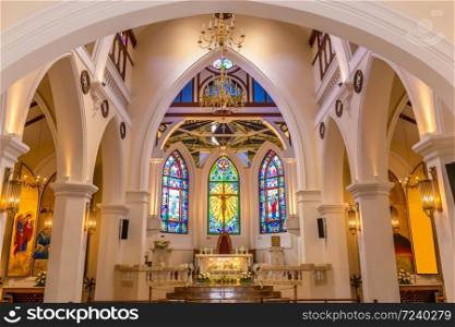 Interior view of beautiful colorful church with empty pews and warm light.