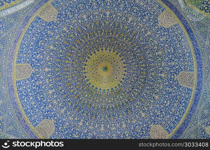 Interior view of lofty dome of the Shah Mosque in Sfahan, Iran covered with mosaic polychrome tiles, intended to give the spectator a sense of heavenly transcendence. Isfahan, Iran - April 22, 2018: Interior view of lofty dome of the Shah Mosque in Sfahan, Iran covered with mosaic polychrome tiles, intended to give the spectator a sense of heavenly transcendence