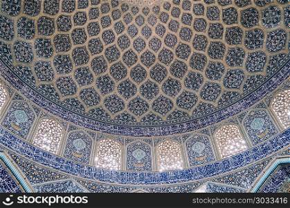 Interior view of the lofty dome of the Shah Mosque in Sfahan, Iran covered with mosaic polychrome tiles, intended to give the spectator a sense of heavenly transcendence. Isfahan, Iran - April 22, 2018: Interior view of lofty dome of the Shah Mosque in Sfahan, Iran covered with mosaic polychrome tiles, intended to give the spectator a sense of heavenly transcendence