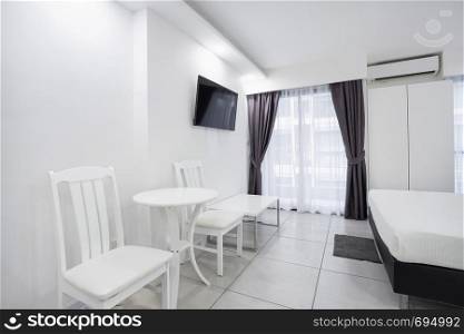 Interior white bedroom design mock up showcase for a boutique hotel room or apartment with chairs and table
