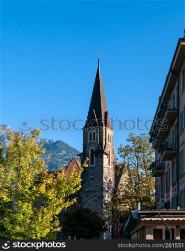 Interlaken, Switzerland - Evening light touch historic old bell tower Schlosskirche Interlaken Castle church with blue sky