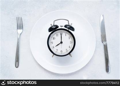 Intermitted farsting diet concept - empty plate with fork and knife and timer. Intermitted farsting diet concept