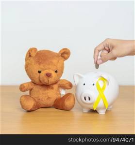 International Childhood Cancer Awareness month, Children toy with golden yellow color Ribbon with Piggy Bank for Donation, Charity, C&aign, Money Saving, Fund and World cancer day concept