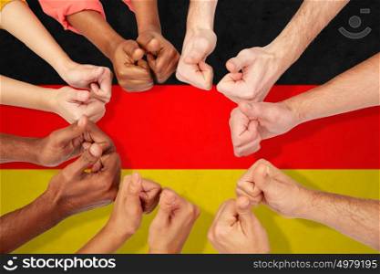 international, diversity, immigration, ethnicity and people concept - hands showing thumbs up over german flag background. hands of international people showing thumbs up