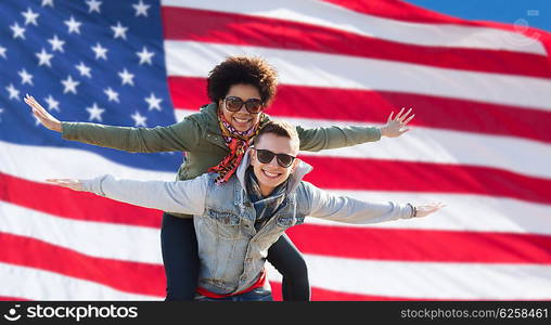 international friendship, freedom and people concept - happy teenage couple in shades having fun over american flag background